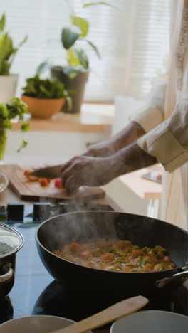 woman cooking delicious curry in kitchen