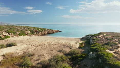 flying to the calamosche beach from the headland in summer in noto, sicily, italy