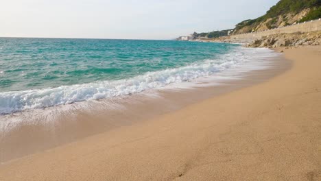 Hermosa-Playa-De-Arena-Mediterránea,-Maresme-Barcelona,-San-Pol-De-Mar,-Con-Rocas-Y-Mar-Tranquilo-Y-Turquesa,-Costa-Brava,-Barcelona