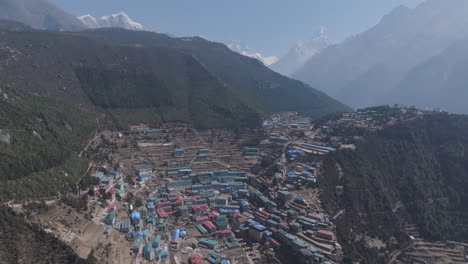 aerial view of namche bazaar, nepal village nestled in himalayan hills and valleys, surrounded by green terrain and diverse habitation, popular for tourism and trekking terrain