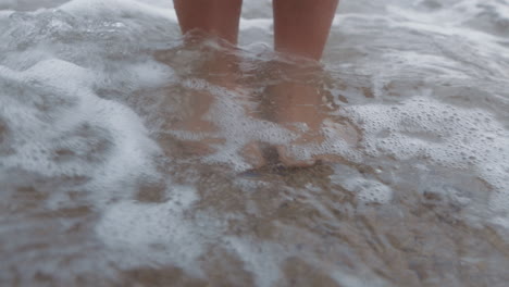 Beach,-woman-feet-and-standing-in-water