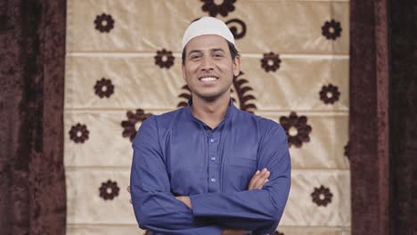 Confident-Muslim-man-standing-crossed-hands-smiling