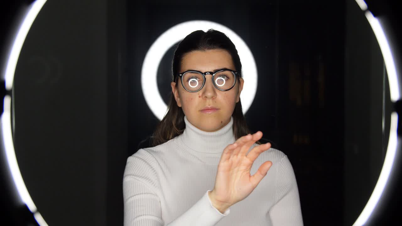 mujer con gafas sobre iluminación blanca en negro