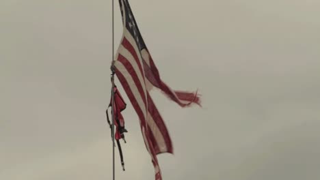 american flag ripped against dark sky