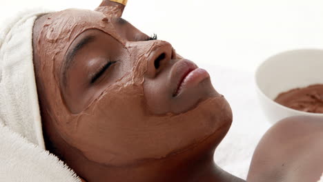 masseuse applying product on her client face