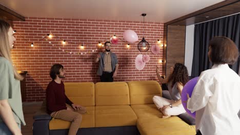 Group-of-people-at-living-room-playing-with-balloon,-have-fun