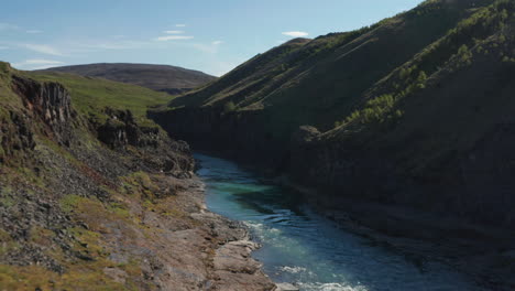 Ojo-De-Pájaro-Del-Río-Glaciar-Jokulsa-Que-Fluye-A-Través-De-La-Formación-De-Lava-De-Dos-Cañones-En-El-Paisaje-Islandés.-Vista-De-Drones-Del-Cañón-Stuolagil-Con-Columnas-De-Basalto.-Increíble-Lugar-Escondido-En-La-Naturaleza