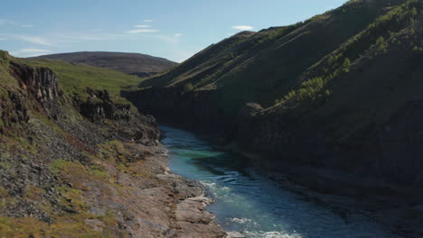 Birds-eye-of-Jokulsa-glacier-river-flowing-through-two-canyon-lava-formation-in-icelandic-landscape.-Drone-view-of-Stuolagil-canyon-with-basalt-columns.-Amazing-hidden-place-in-nature