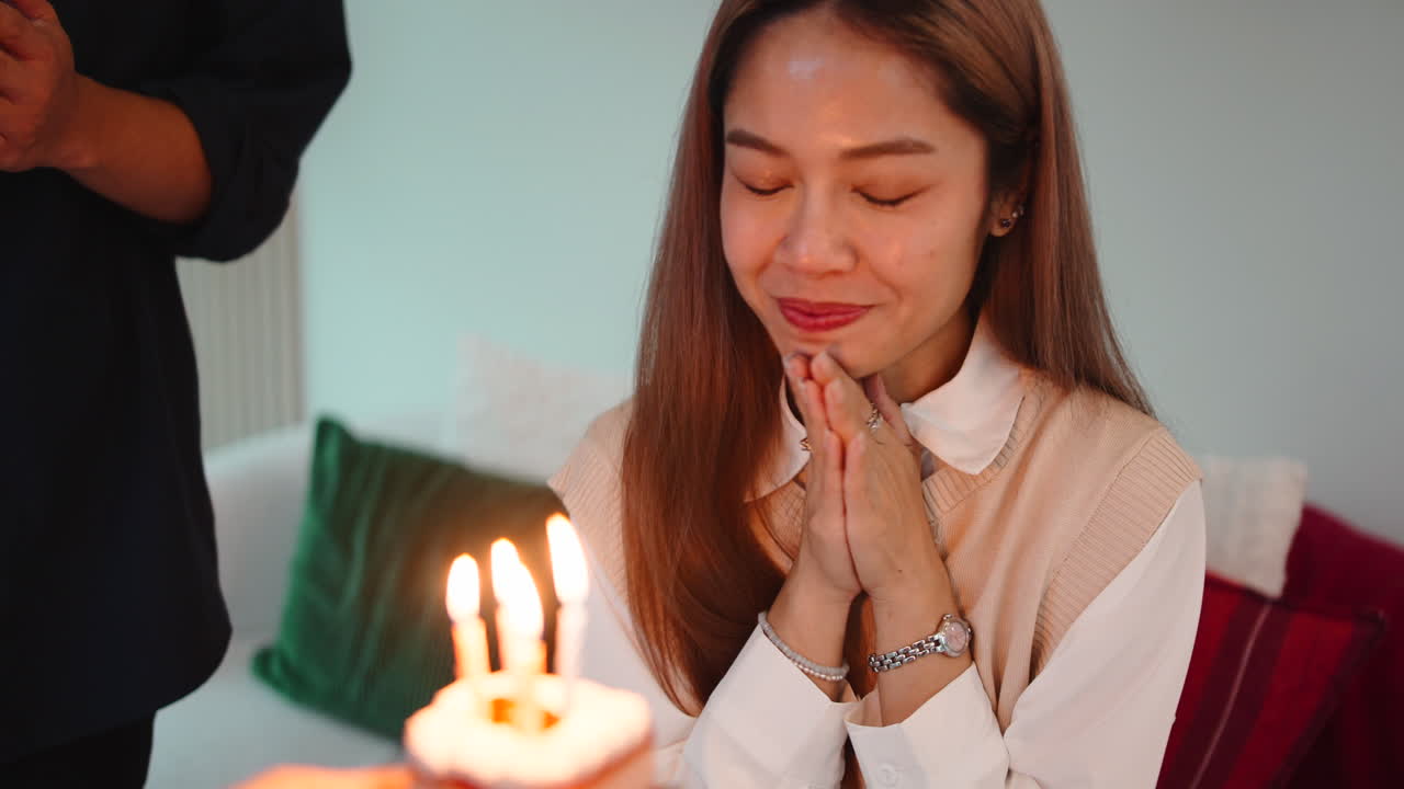 Wanita Asia merayakan ulang tahun dengan kue dan lilin