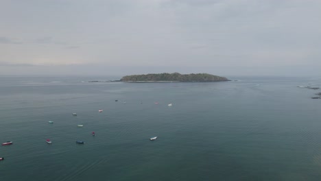 Santa-catalina,-panama-with-boats-floating-near-the-coastline-on-a-cloudy-day,-aerial-view