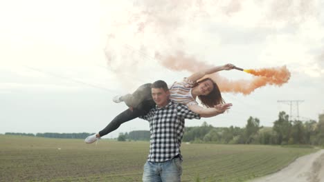 couple with colored smoke bombs resting outdoors