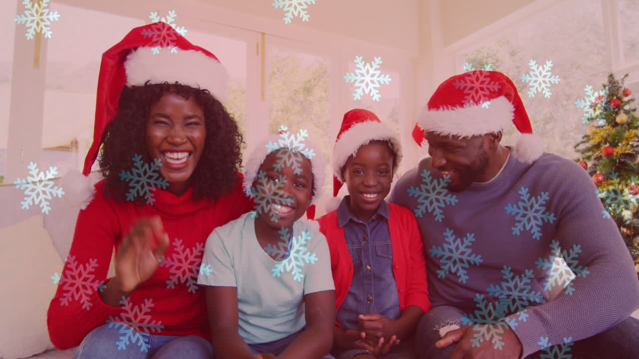 animación de la nieve cayendo sobre la familia sonriente con sombreros de santa agitando las manos