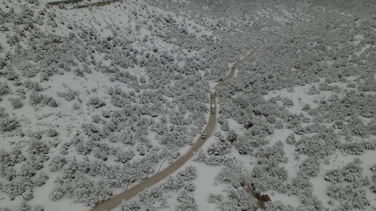 유타의 눈 덮인 산과 나무를 따라 도로를 달리는 차량