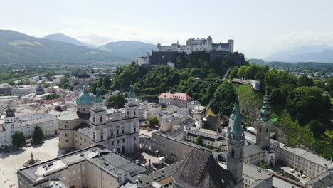 drone passes salzburg’s historic skyline, hohensalzburg fortress and cathedral