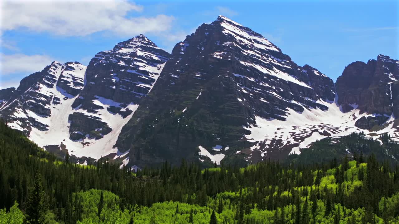 Maroon Bells Peak North Maroon 14er Elk Range Rocky Mountains Wilderness aerial drone Colorado spring summer morning sunny blue sky snow melt Aspen Snowmass Trees White River National Forest pan right