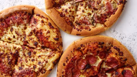 tres pizzas de estilo americano servidas en una mesa