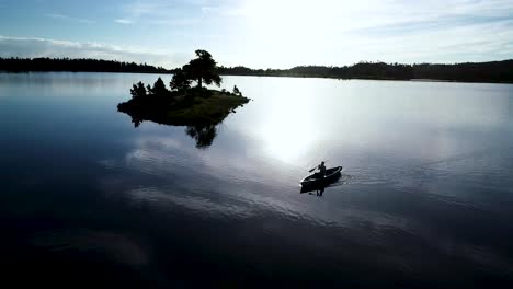 beautiful colorado sunrise on a lake with a silhouette of a canoe against the rising sun