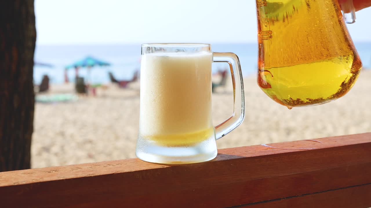 해변 에 있는 유리잔 에 맥주 가 여 있다