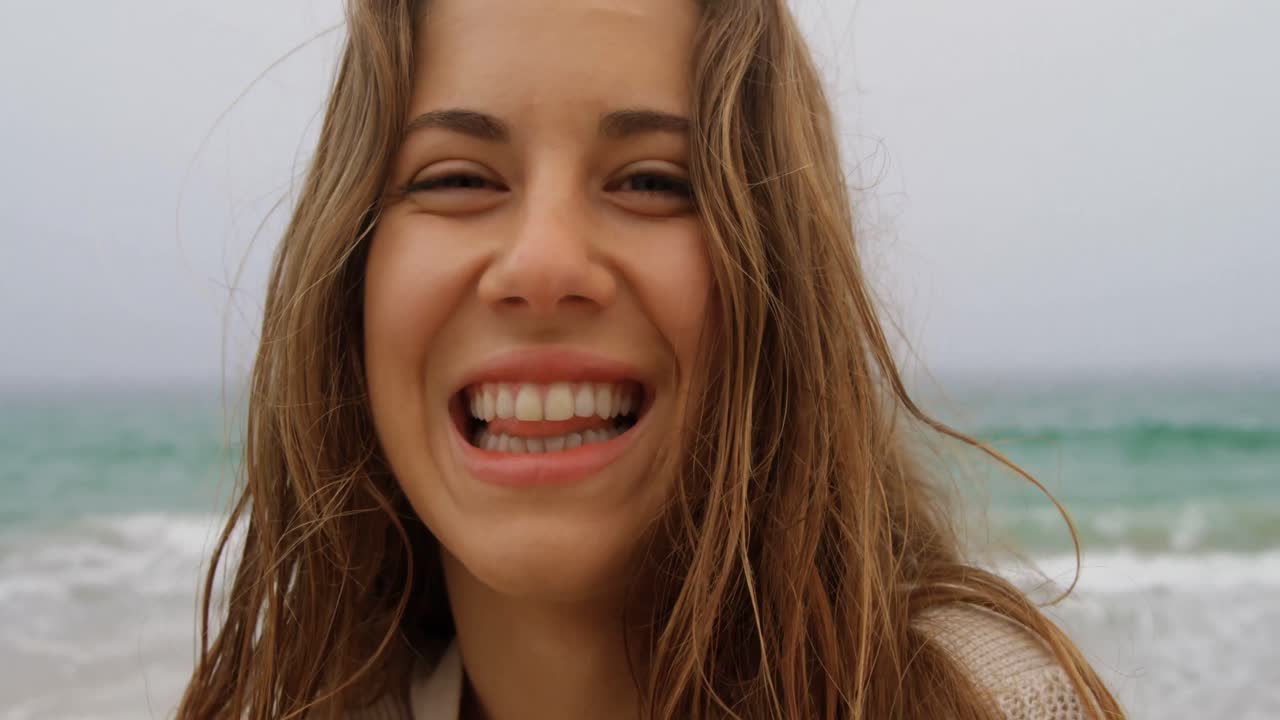 vista frontal de una mujer caucásica de pie en la playa 4k