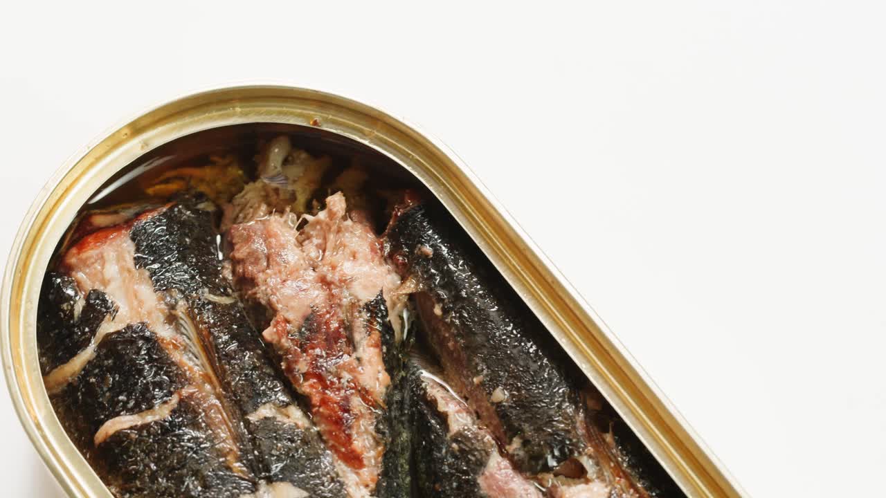 Opening sardine fish or tuna can, man open the canned anchovy on the table. Close up on professional kitchen.