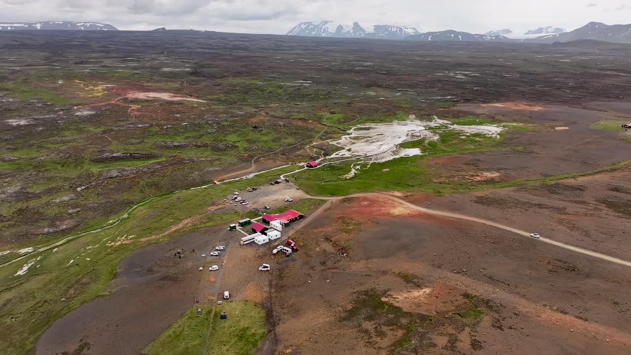 Aerial drone footage circling Hveravellir hot spring in the highlands of Iceland, with steaming pouring out of the geothermal pools below