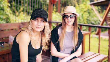 dos chicas bonitas sentadas en una casa de verano sonriendo