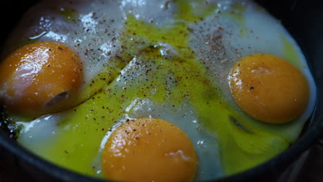 sprinkle spices over fried eggs on a pan