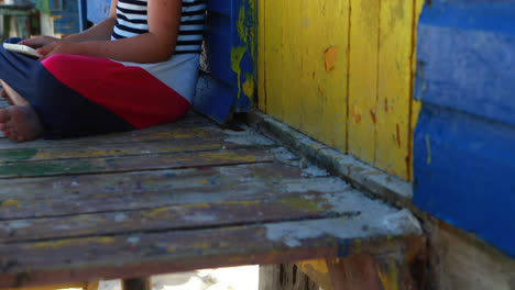 Mädchen-Mit-Digitalem-Tablet-In-Der-Nähe-Einer-Bunten-Strandhütte