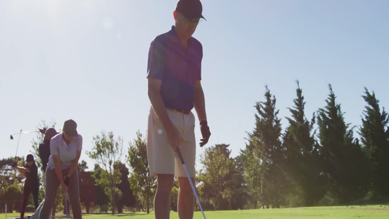 밝은  ⁇ 은 날에 골프 코스에서 골프를 연습하는 노인들