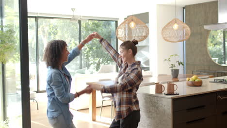 dancing together in kitchen, lesbian couple enjoying time at home