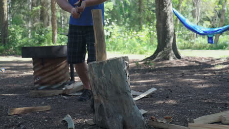 Male Camper Uses Hatchet In Chopping Wood For Outdoor Cooking In The Forest