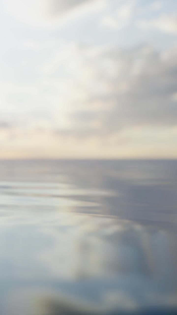 Calm water reflects cloudy sky at sunset near coastal location
