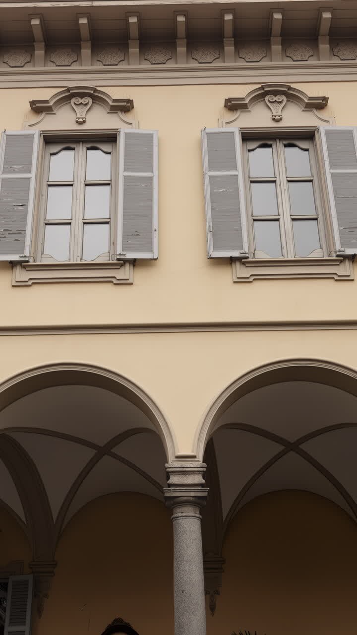 Dettaglio architettonico di una facciata di edificio con finestre e archi