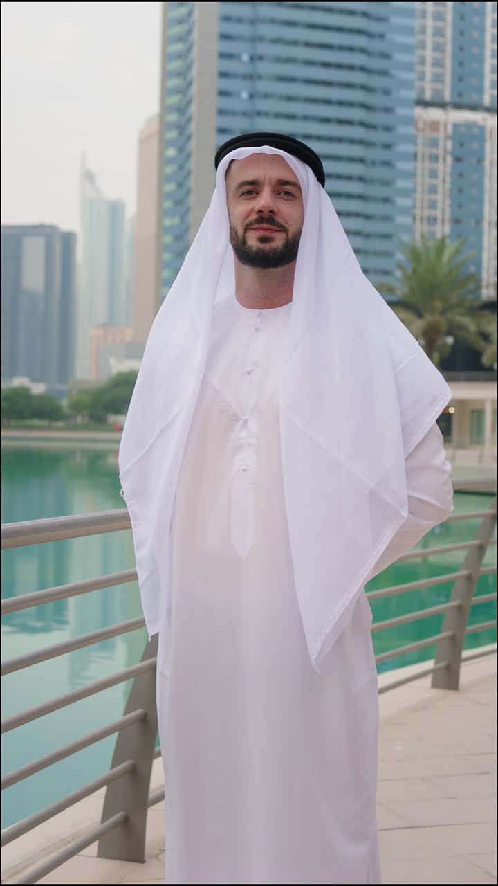 Ritratto verticale di un uomo arabo del Golfo in abiti tradizionali emiratini con torri e grattacieli sullo sfondo.