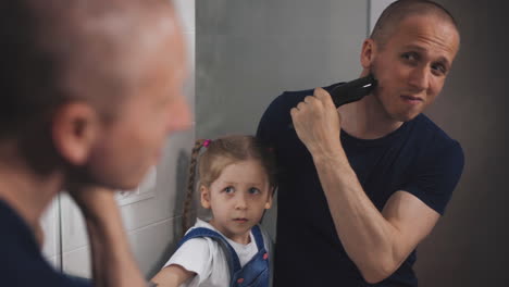 dad stands in bathroom near mirror