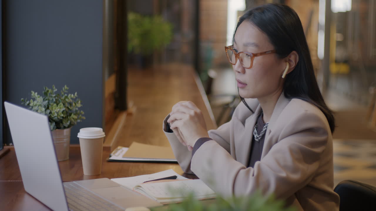 コーヒーショップでビデオ通話をしている女性