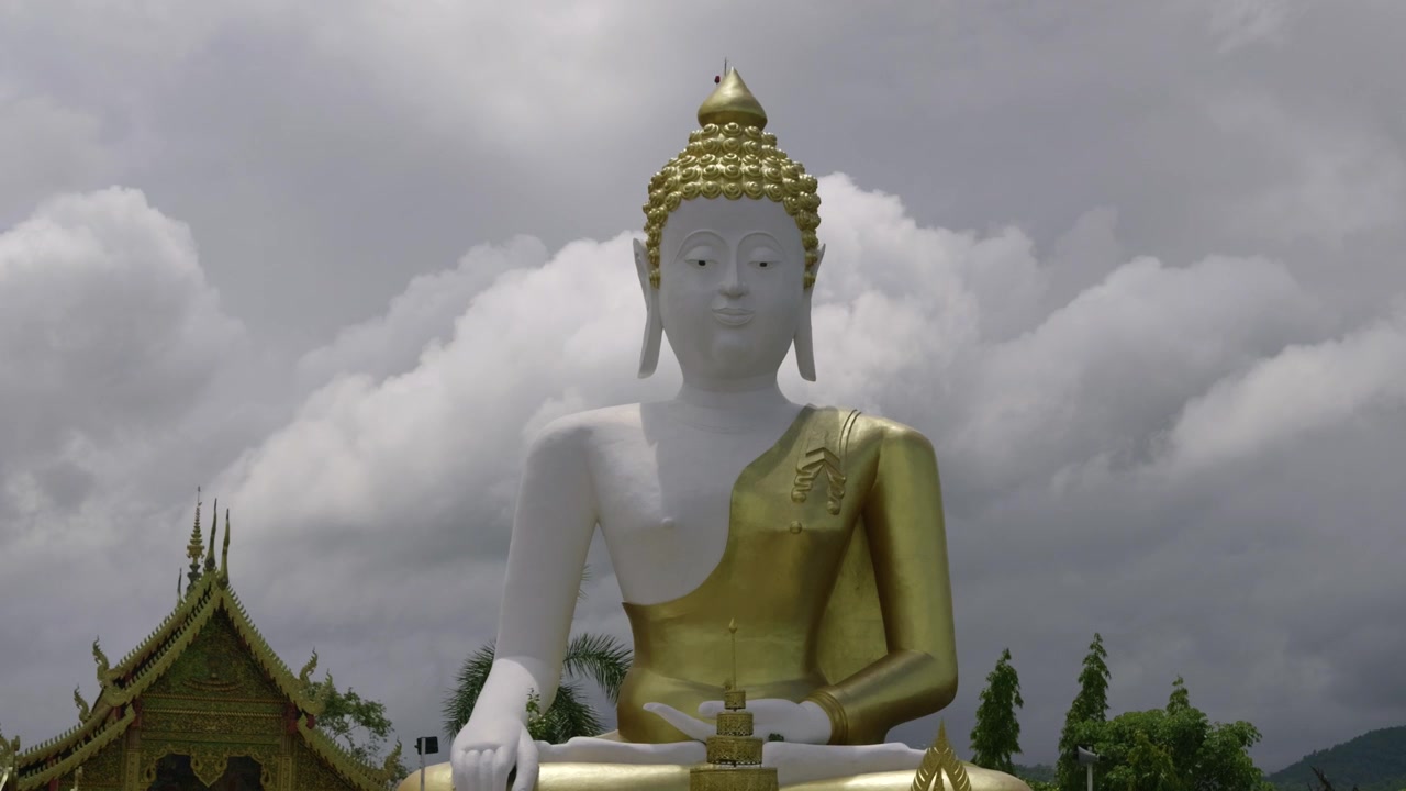 Bella statua di Buddha seduta sullo sfondo di un cielo nuvoloso.