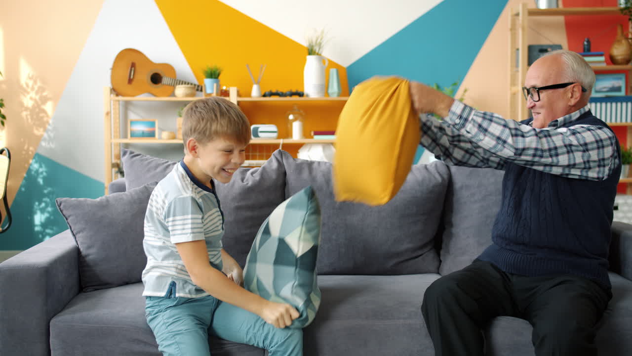 Grandfather and Grandson Having Fun Pillow Fight