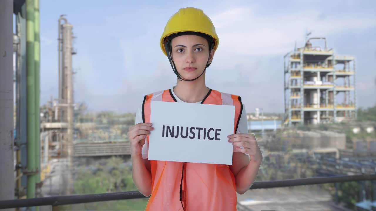 triste trabajadora de la construcción india con una pancarta de injusticia
