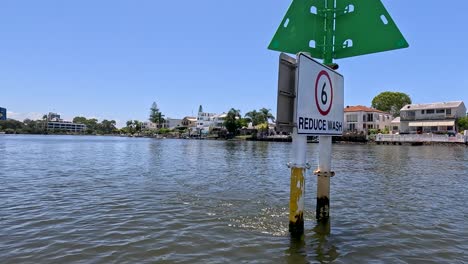 boat navigates past buoy with speed warning