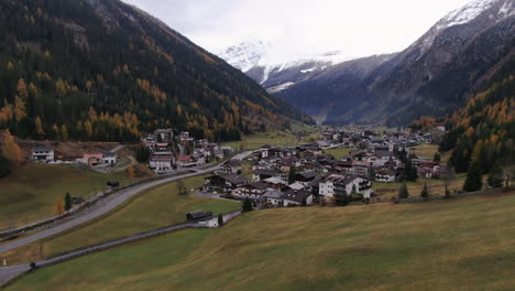 Aerial-flight-over-rural-fields-with-small-Austrian-village-between-mountains-in-autumn-season---Kauntertal,-Austria