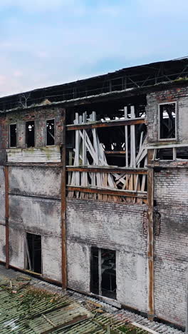 aerial view from the air to an abandoned factory. old industrial building for demolition. vertical video