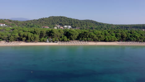 aerial: koukounaries sandy beach with turquoise crystal clear water in skiathos island, greece