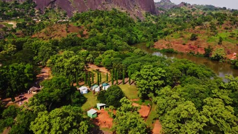 Aerial-of-small-cabins-in-a-large-green-park-in-Nigeria,-Africa