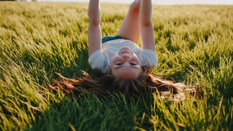 young girl smiling while lying in green grass