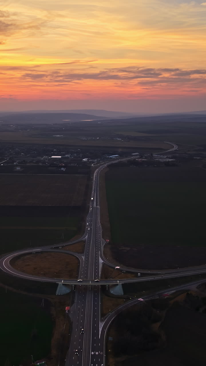 Aerial drone view of cars driving on the highway in Moldova at sunset. Vertical