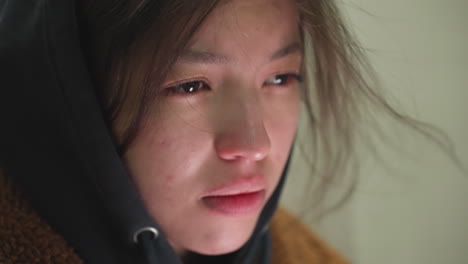 close-up of a young girl's face, her hair slightly disheveled, with a deeply depressed expression. her eyes are cast downward, reflecting a state of concern and contemplation