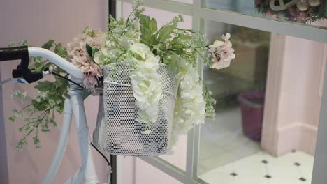 white bicycle with a basket of flowers