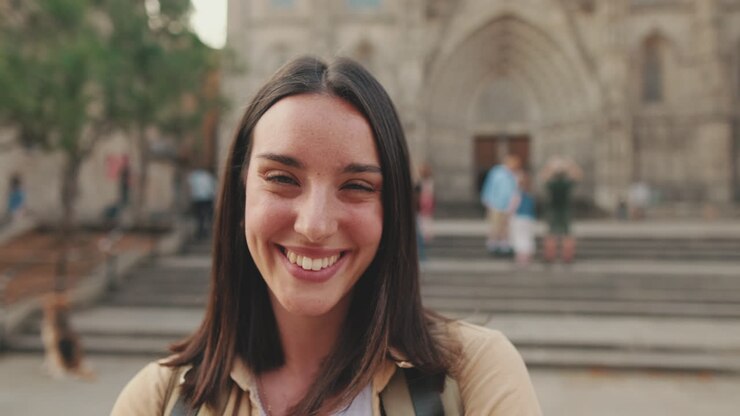 Giovane donna felice sorridente alla fotocamera in strada