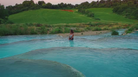 4k-Uhd-Cinemagraph---Nahtlose-Videoschleife-Einer-Jungen-Frau,-Die-Sich-In-Einem-Becken-Mit-Heißen-Thermalquellen-In-Saturnia,-Italien,-Entspannt